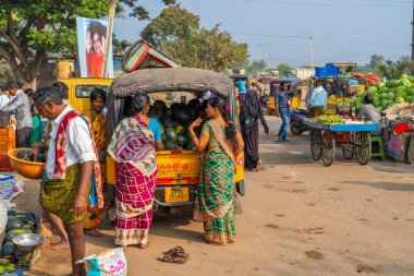 Puttaparthi, Andra Pradesh - India - January 21.2023: Two women buy watermelon on a local Indian vegetable market in Puttaparti
