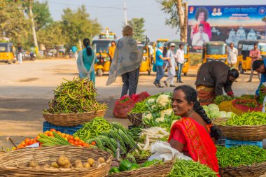 Puttaparthi, Andra Pradesh - India - January 21.2023: A women selling vegetables on the local Indian market in Puttaparthi