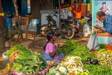 Puttaparthi, Andra Pradesh - India - January 21.2023: A women selling vegetables on the local Indian market in Puttaparthi