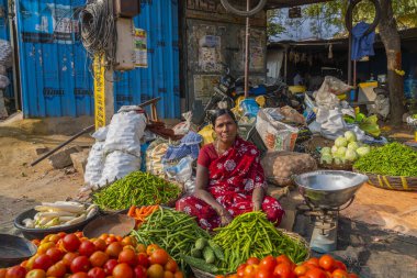 Puttaparthi, Andra Pradesh - India - January 21.2023: A women selling vegetables on the local Indian market in Puttaparthi
