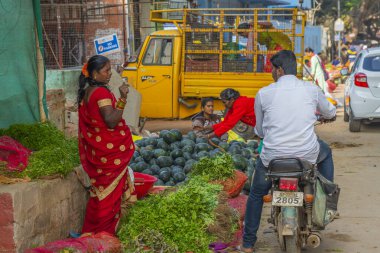 Puttaparthi, Andra Pradesh - India - January 21.2023: A woman selling fresh herbals on the local Indian vegetable market