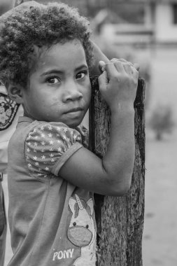 Raja Ampat, Indonesia -February 6. 2023: Black white picture of a girl looking to the camera in Raja Ampat, West Papua