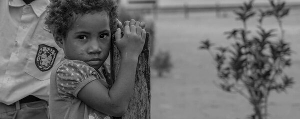 Raja Ampat, Indonesia -February 6. 2023 : Black white picture of a girl looking to the camera in Raja Ampat, West Papua, panorama