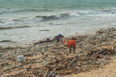 Jimbaran Sahili, Endonezya - 13 Şubat 2023 Bali 'de Jimbaran Sahili çöplerle dolu, çöpte kullanılacak şeyleri arayan bir insan