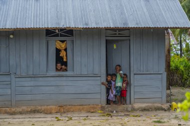 Raja Ampat, Batı Papua, Endonezya, Şubat 06.2023: Mavi bir evde Raja Ampat 'ta oynayan yerli papualı çocuklar