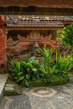 Bali 'deki Ubud' da doğal taştan bir fil heykeli olan bir evden giriş.