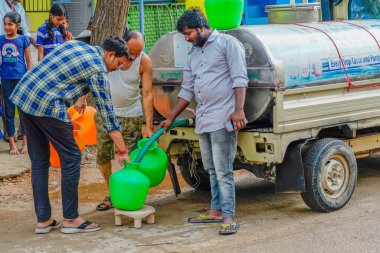 Puttaparthi, Hindistan - 01 Eylül 2023: Puttaparthi 'deki mobil bir su tankından üç kişi içme suyu aldı