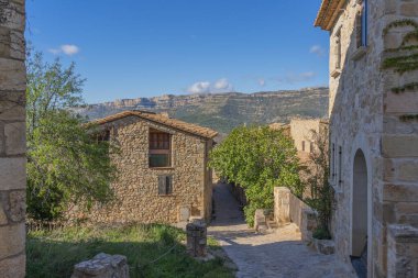 Siurana dağ köyünün merkezindeki tarihi taş evler mavi gökyüzü, Tarragona