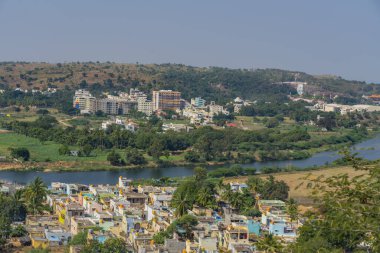 Puttaparthi 'den yeşil ağaçlar, binalar, tapınaklar ve Hindistan' ın Sai Baba kentinden aşramla manzara.