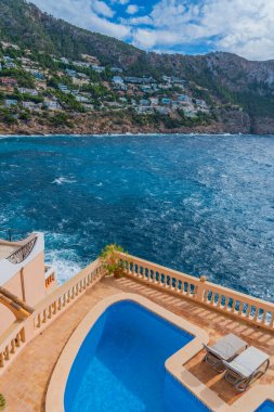 Port Andratx, İspanya 'da Mallorca adasında halka açık bir havuzu ve evleri olan kıyı şeridi manzarası.