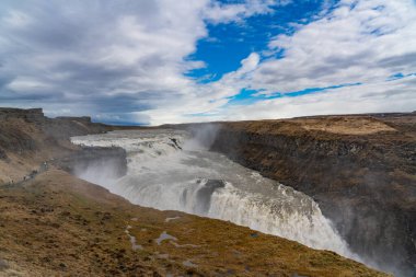 İzlanda 'da bulutlu bir günde Mai' deki altın çemberde martı şelalelerinin üzerinde çağlayan sular.