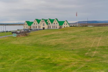 Laugarvatn, İzlanda - Mai 26.2024: Heradskolinn konuk evi, Laugarvatn Gölü 'nde tarihi bir okul. Binalar yeşil çatılarla bembeyaz..