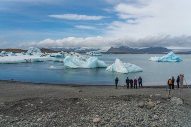 Joekularson, Island - Mai 24.2025: Joekulsarlon Glacier Lagoon Landscape with blue ice and people on the shore clipart