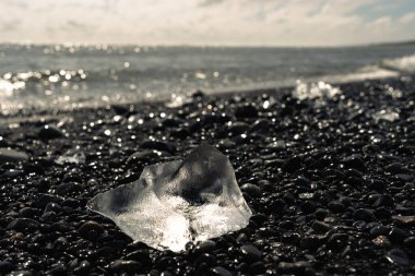 İzlanda 'daki Diamond Plajı' ndaki volkanik siyah kumsalda buz parçaları ve kırılmış buzdağları.