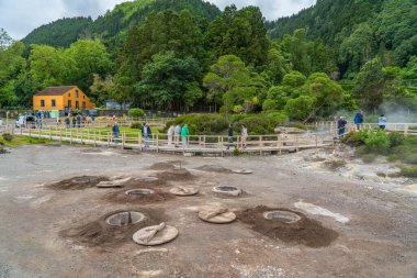 Furnas, Portekiz - 7 Haziran 2024: Sao Miguel 'deki Furnas Gölü' ndeki kaplıcalar, turistle Azores ve buharda yemek pişirme delikleri