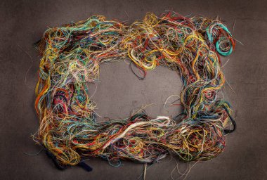 Koyu gri arkaplanda renkli karışık iplikler