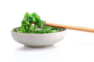 Çubuklarda Japon yosun salatası var. Japon mutfağı - Wakame salatası, beyaz arka planda izole edilmiş Chuka yosun salatası.