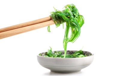 Çubuklarda Japon yosun salatası var. Japon mutfağı - Wakame salatası, beyaz arka planda izole edilmiş Chuka yosun salatası.