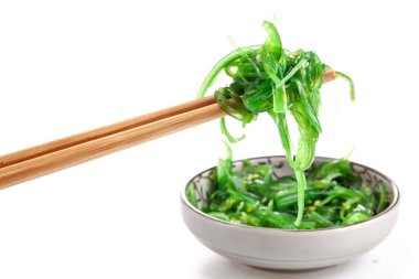 Çubuklarda Japon yosun salatası var. Japon mutfağı - Wakame salatası, beyaz arka planda izole edilmiş Chuka yosun salatası.