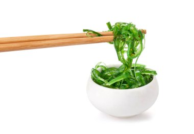Çubuklarda Japon yosun salatası var. Japon mutfağı - Wakame salatası, beyaz arka planda izole edilmiş Chuka yosun salatası.