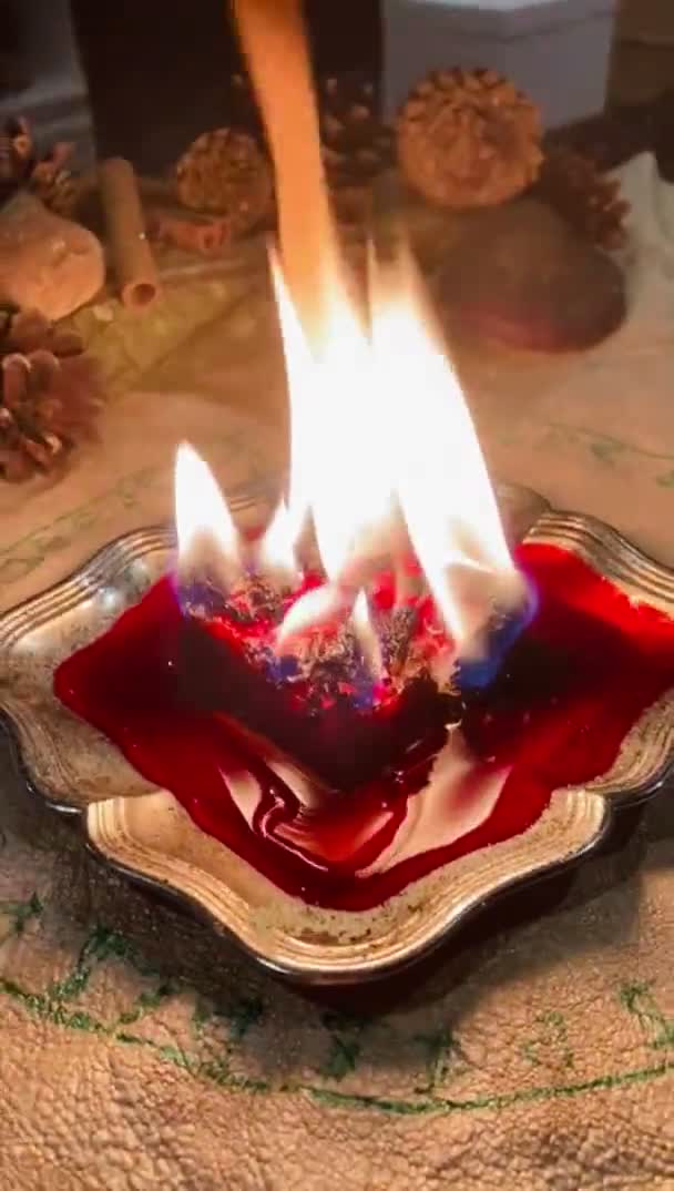 红色的蜡烛点缀着药草 货币符号刻在羊皮上 侧面挂着松果和肉桂 执行优勒繁荣仪式魔法 — 图库视频影像