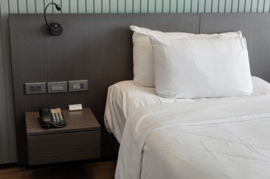 Modern yatak odası, beyaz yastıklı ve komodinli.