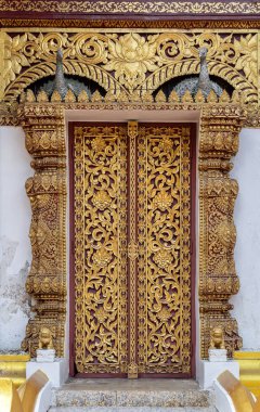 Ahşap kapıya oyulmuş çiçek deseni, tapınakta Tayland sanat tarzı.