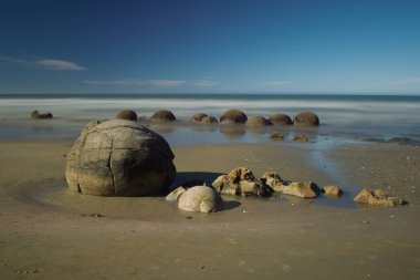 Landmark Moeraki Boulders dramatik şafak gökyüzü altında Güney Adası'nın doğu kıyısında.