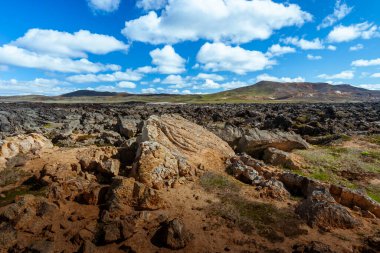 Myvatn yakınlarındaki İzlanda 'nın dağlık kesimlerinde inanılmaz lav tarlaları, siyah eski lav akıntıları ve volkanik kayalar, arka planda dağlar