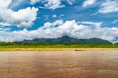 Amazon Nehri ve ormanı üzerinde sağanak yağış var. Fırtınanın ortasında suda yüzen küçük bir tekne var.