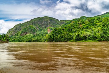 Amazon Nehri ve ormanı üzerinde sağanak yağış var. Fırtınanın ortasında suda yüzen küçük bir tekne var.