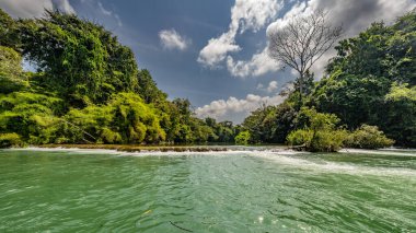Amazon Nehri ve ormanı üzerinde sağanak yağış var. Fırtınanın ortasında suda yüzen küçük bir tekne var.