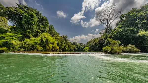 Amazon Nehri ve ormanı üzerinde sağanak yağış var. Fırtınanın ortasında suda yüzen küçük bir tekne var.