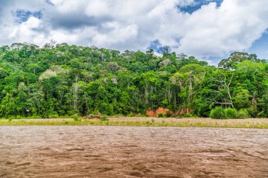 Amazon Nehri ve ormanı üzerinde sağanak yağış var. Fırtınanın ortasında suda yüzen küçük bir tekne var.