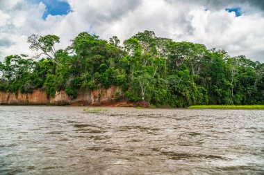 Amazon Nehri ve ormanı üzerinde sağanak yağış var. Fırtınanın ortasında suda yüzen küçük bir tekne var.