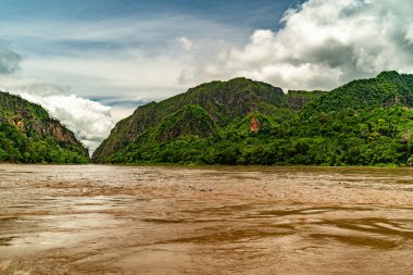 Amazon Nehri ve ormanı üzerinde sağanak yağış var. Fırtınanın ortasında suda yüzen küçük bir tekne var.