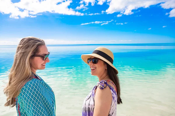 穏やかなビーチで2人の笑顔の女性が一緒に美しいビーチ休暇を楽しんでいます 素晴らしい人々と太陽の下で楽しみを持っています ライフスタイル旅行写真 — ストック写真