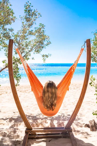 从后面看一个漂亮的女人在一个独特的吊床上放松 可以看到加勒比海的壮丽景色 放松和欣赏大自然的美丽 — 图库照片