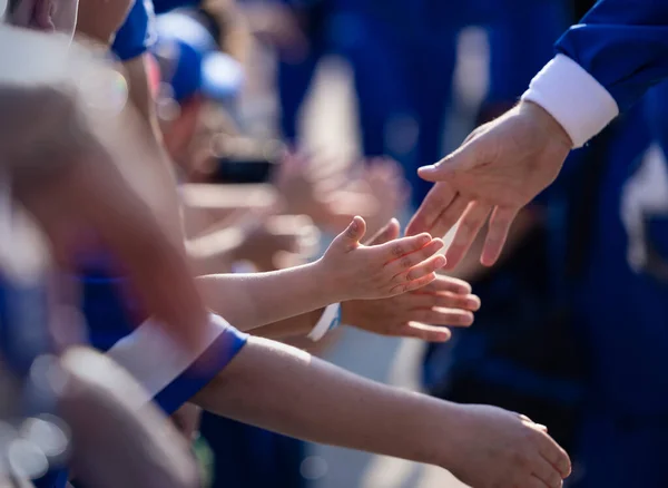 几个小孩子在体育场外走过的时候 对他们的体育英雄们举起了拳头 与体育明星握手的年轻男孩的近照 — 图库照片
