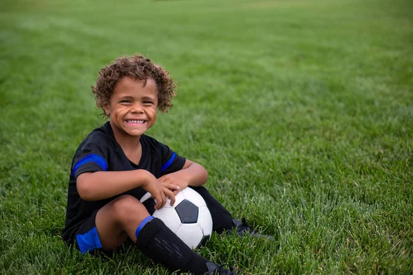 Νεαρός Αφρο Αμερικανός Ποδοσφαιριστής Κάθεται Ένα Γήπεδο Χωρίς Έκφραση Γρασίδι — Φωτογραφία Αρχείου