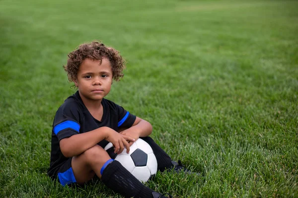 Junger Afroamerikaner Sitzt Vor Einem Fußballspiel Ausdruckslos Auf Einem Rasenplatz — Stockfoto