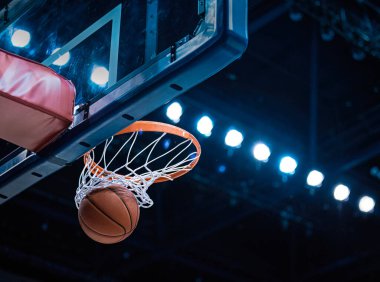 Basketbol potası çemberin içinden geçerken basket atıyor ve ağda bir hareketlilik yapıyor.
