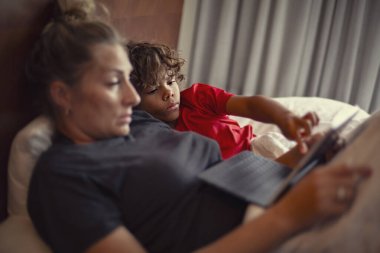 Bir anne ve oğul bir tablet bilgisayarın başındayken teknolojiyi kullanarak birlikte öğreniyorlar. Mobil öğrenim için konsept fotoğraf ve tekonoloji ile ebeveynsel rehberlik ve öğretim
