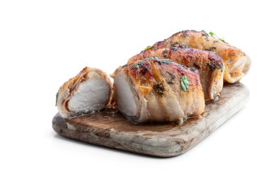 Chicken  breasts wrapped in bacon on wooden board isolated on white 