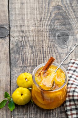 Cam kavanozlarda ev yapımı ayva reçeli ve ahşap masa yapraklı taze bıldırcın. 