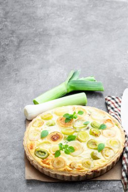 Gri arka planda pırasa ve peynirli kiş 