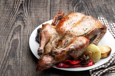 Beyaz tabakta elmayla doldurulmuş fırında ördek. 