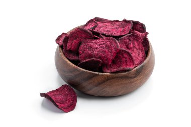 Beyaz arka planda izole edilmiş ahşap kasede kurutulmuş pancar parçaları. 