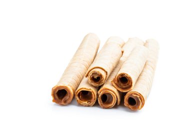 Beyaz arka planda kaynamış yoğunlaştırılmış sütle birlikte waffer dürümlerinin lezzeti 