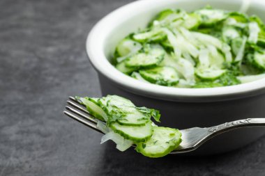 Gri arka planda soğanlı salatalık. 